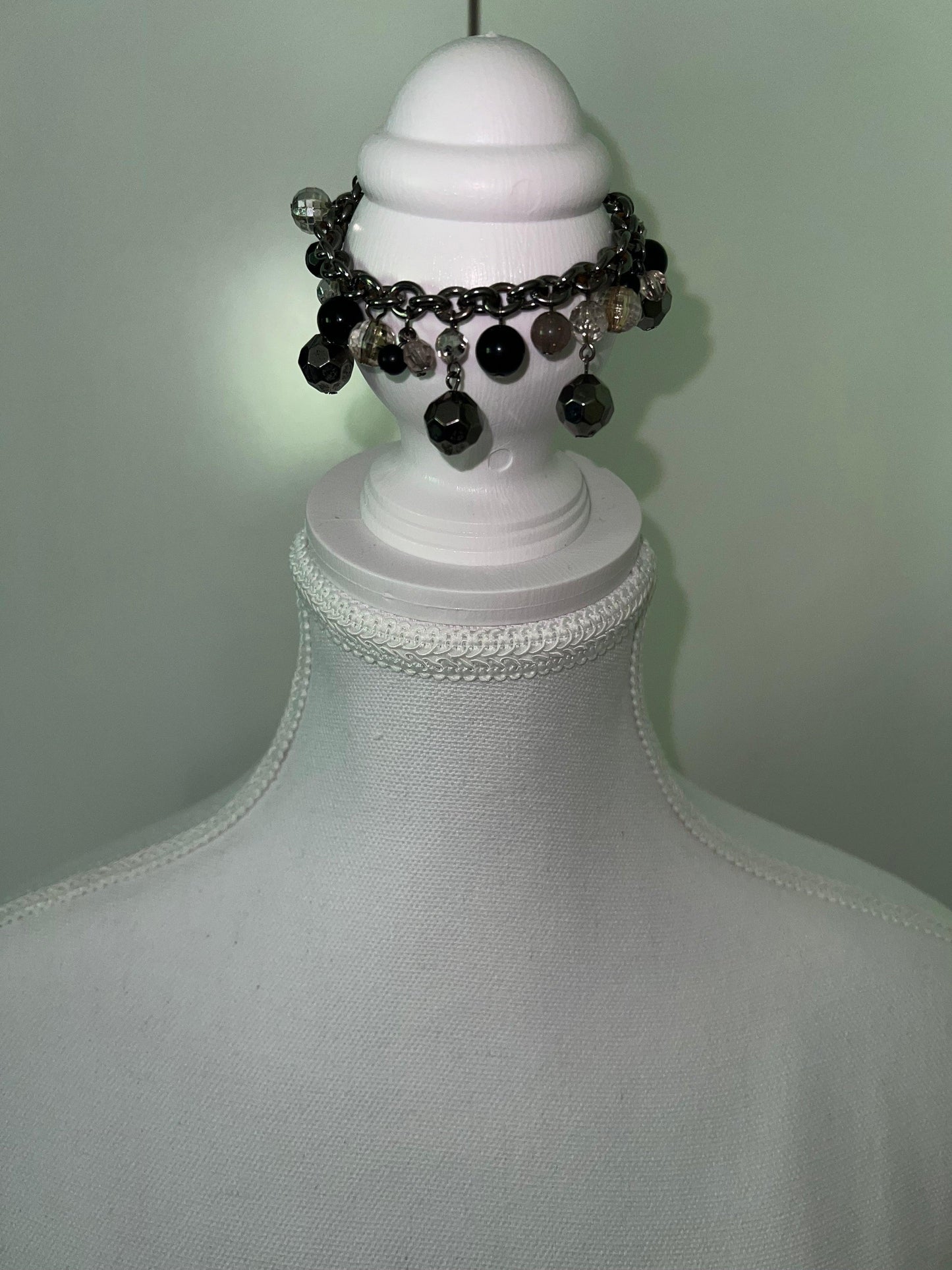 Black & grey beaded bracelet with a durable metal chain, displayed on a white mannequin.