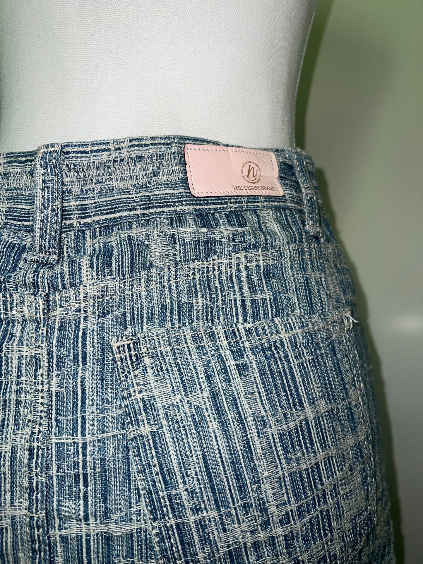 Light blue denim skirt, striped, with a pink "The Denim Brand" label on the waistband.
