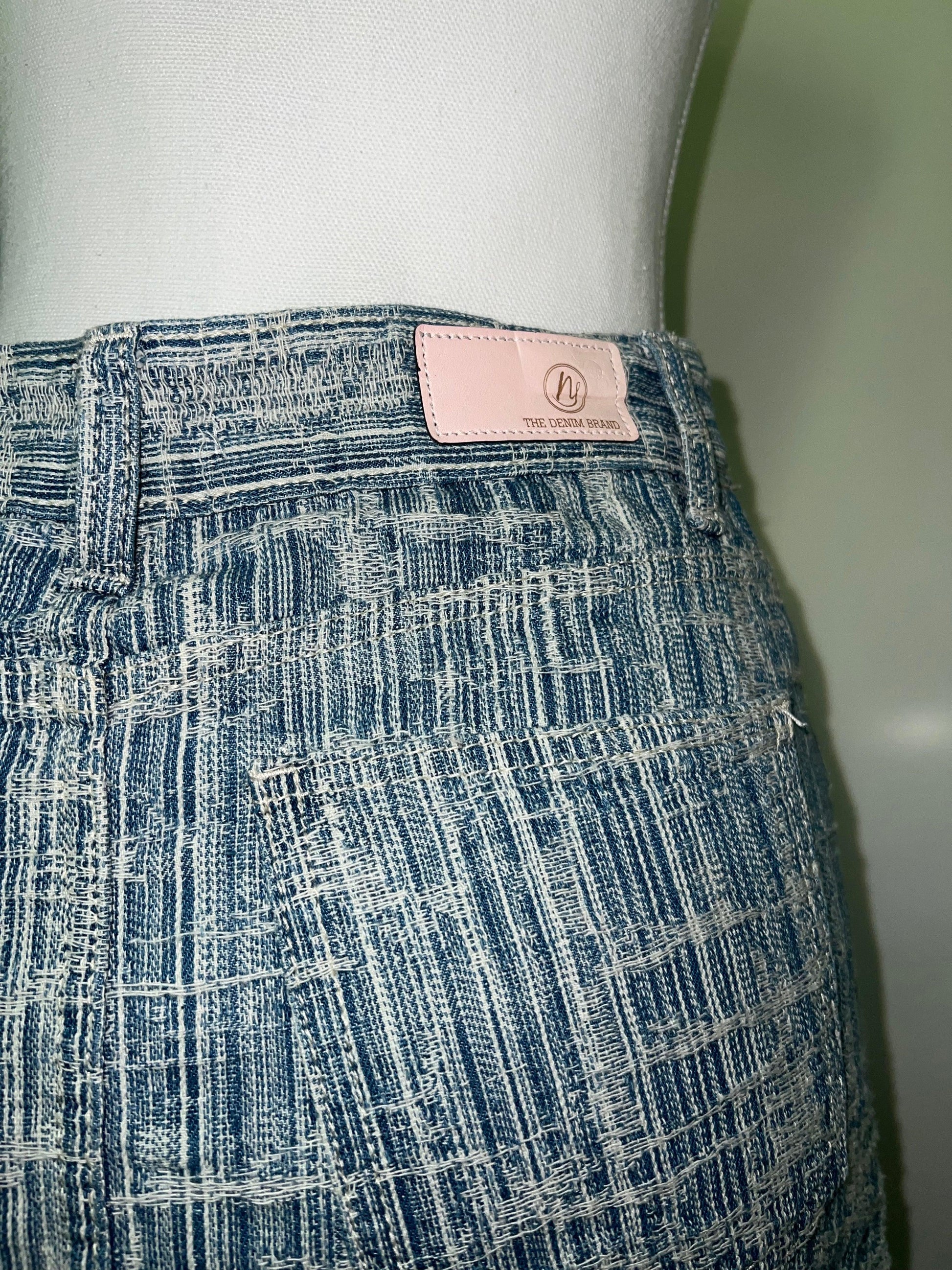 Light blue denim skirt, striped, with a pink "The Denim Brand" label on the waistband.
